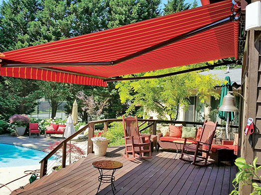 an extended, red Series 7700 Retractable Awning