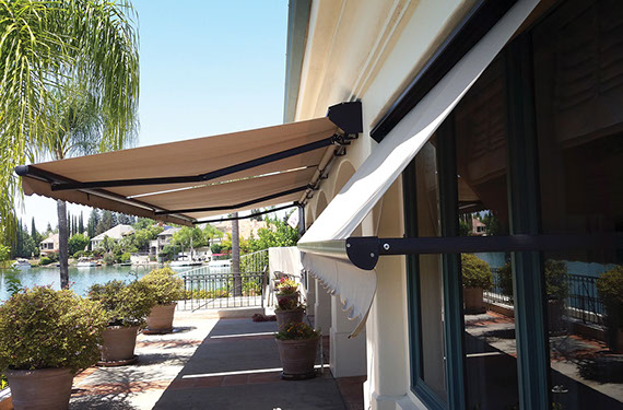 a backyard with an extended Series G150 Retractable Awning